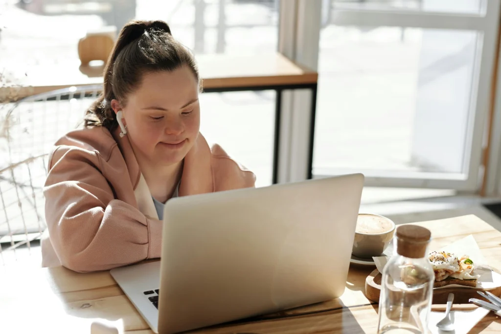 a business owner with downs syndrome sitting at a desk with her laptop