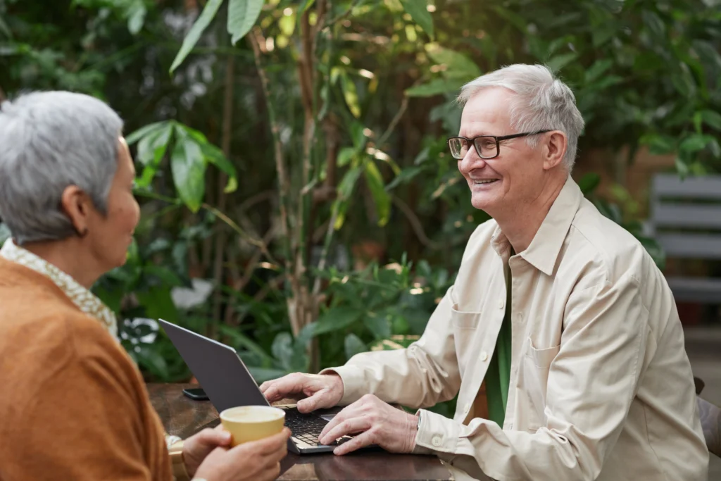 an older business man sitting at a table with a colleague