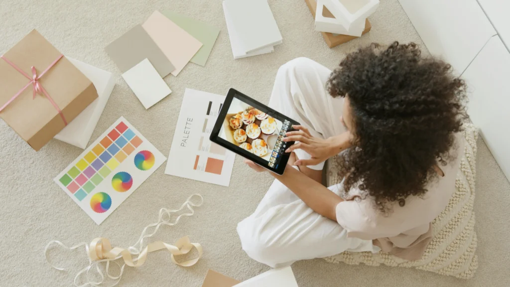 view from above is a woman sitting on the floor with her ipad looking at cupcake orders